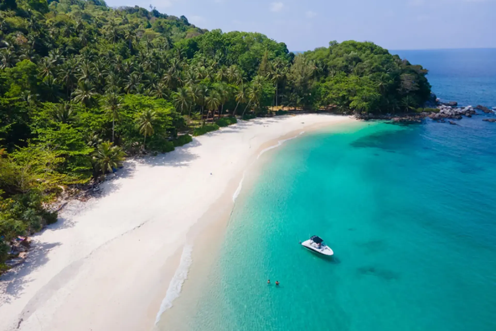 Freedom Beach with white sand blue-green water and boat